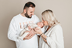 Boho Familie mit Baby - Mutter küsst Newborn